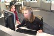 Female youth working on a computer with the assistance of a female adult