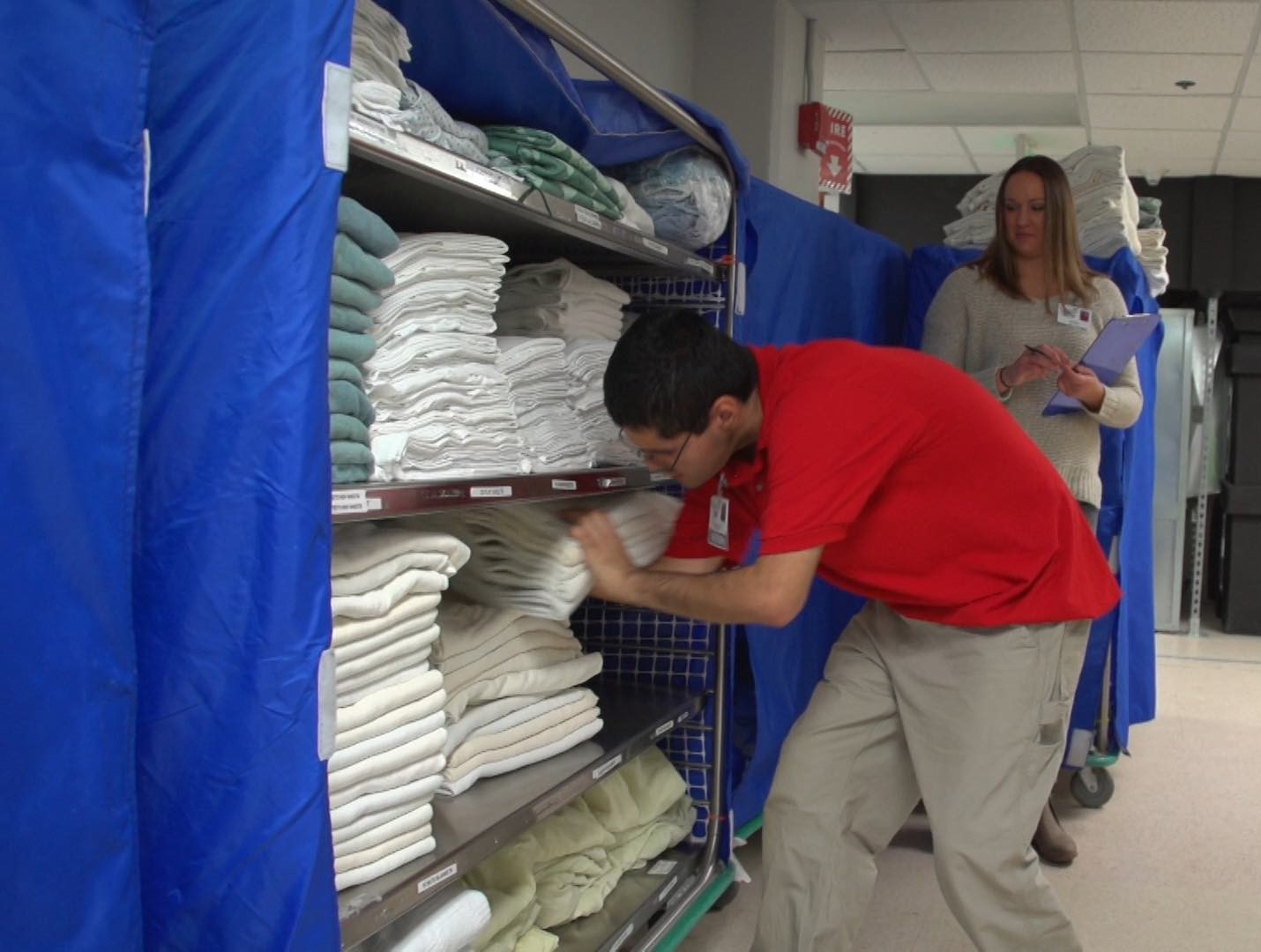 Male youth working in hospital folding towels